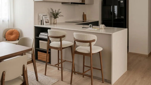Two upholstered wooden bar stools placed at a modern kitchen island in a warm Singapore home, showing proper counter stool height and spacing.