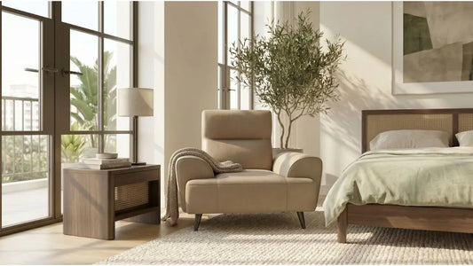 Calm bedroom remodel with beige armchair, wood bedside table, table lamp, cane bed frame, and soft natural light