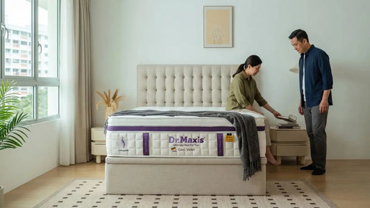 Couple comparing Dr Maxis mattress support in a Singapore bedroom before choosing a spring mattress