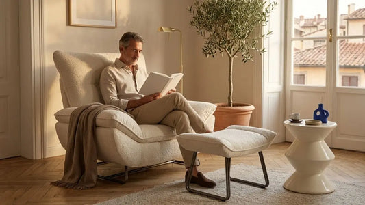 Cream fixed armchair with matching ottoman in a bright Italian-inspired living room, showing comfortable lounge placement for daily reading