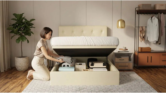 Woman storing folded bedding inside a cream storage bed with gas-lift mechanism