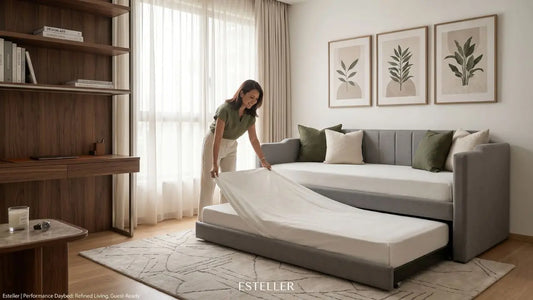 Beige upholstered day bed with pull-out trundle in a refined Singapore study lounge with warm wood desk, soft curtains, and city views.