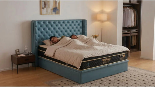 Couple sleeping on a Dr Maxis king mattress with teal tufted bed frame in a modern Singapore bedroom