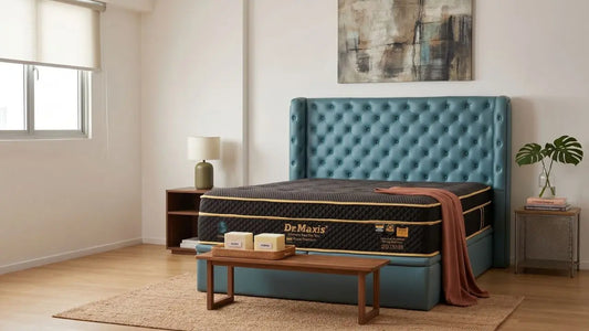 Dr Maxis mattress on a teal bed frame in a bright bedroom with bedside tables, blanket, and wall art