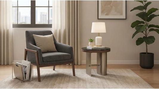 Grey fabric armchair with round side table, table lamp, and books in a calm Singapore living room setup
