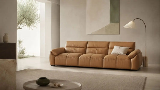 Italian-inspired living room with a camel leather sofa, open floor space, neutral decor, and balanced negative space for a calm modern home