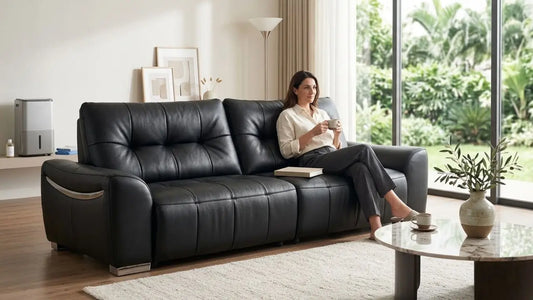 Woman enjoying a well-maintained black leather sofa in a bright Singapore living room with indoor greenery