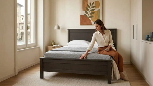 Dark wood bed frame with grey mattress in a modern bedroom showing proper mattress and bed frame compatibility