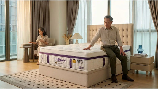 Man checking mattress support and edge feel in a Singapore condo bedroom before choosing firmness