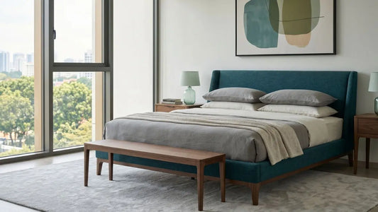 Natural wood bed frame with sage upholstered headboard in a bright Singapore bedroom with neutral bedding and warm timber bedside tables