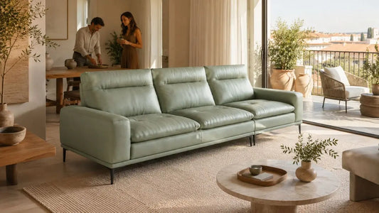 Sage green leather sofa in an Italian-inspired living room with open balcony, warm natural light, and refined indoor-outdoor furniture styling