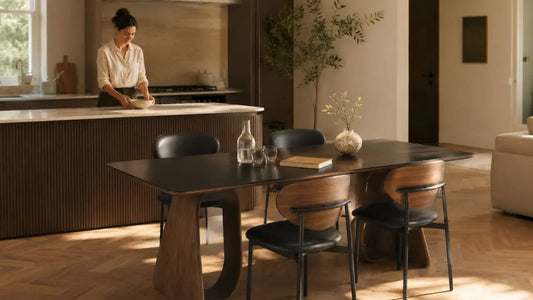 Italian-inspired open kitchen and dining room with a dark wood dining table and black upholstered chairs in a warm modern home.