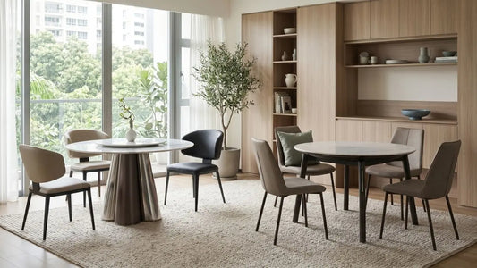 Pedestal and four-leg round dining tables shown side by side in a modern Singapore dining room for legroom and stability comparison.