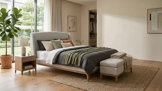 Raised upholstered bed frame with bench, bedside table, and open wardrobe in a spacious Singapore bedroom.