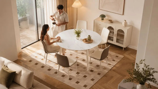 Round dining table in a warm Italian-inspired dining room with marble-look surface, upholstered chairs, and refined neutral styling