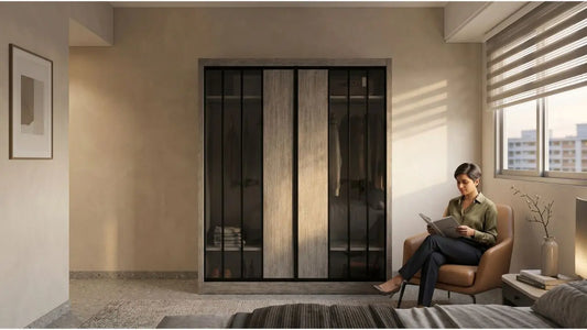 Woman reading beside a grey sliding door wardrobe in a warm bedroom, highlighting wardrobe sizing for HDB and condo homes