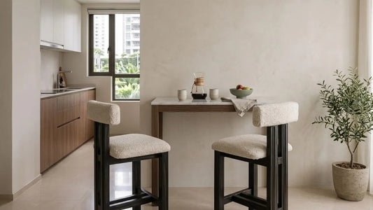 Small kitchen with a slim wall bar table and two upholstered stools in a warm neutral Singapore home