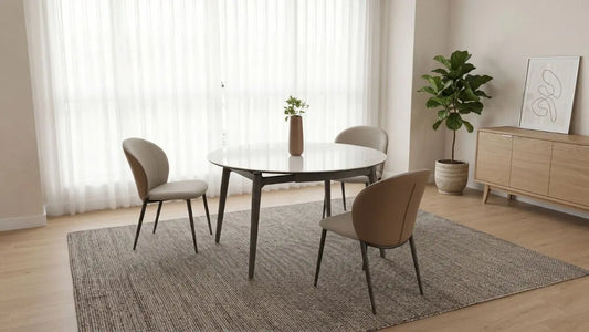 Round 4-seater dining table in a bright Singapore dining room with neutral chairs, rug, and sideboard