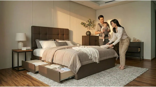 Parents setting up a storage bed for a new baby in a warm Singapore bedroom, showing practical family bedroom furniture