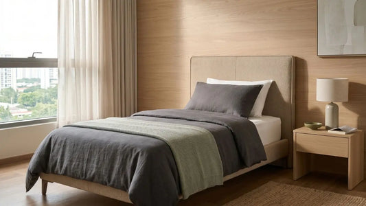 Super single bed in a warm wood Singapore bedroom with soft bedding, bedside table, and natural daylight
