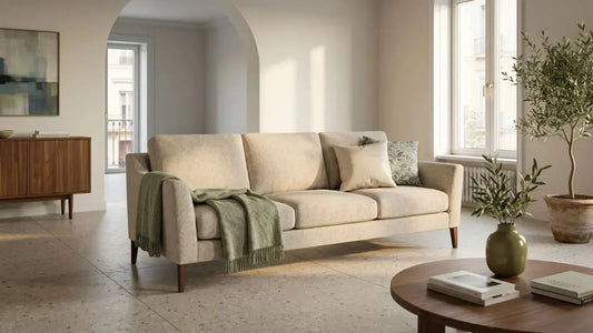 Low-arm beige sofa with tapered timber legs in a calm European-inspired living room with warm neutral tones