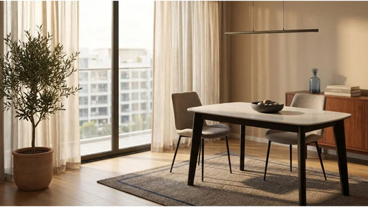 White dining table with two upholstered chairs in a warm condo dining room with balcony and natural light white-dining-table-condo-dining-
